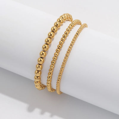 Set aus goldfarbenen Kugelarmbändern