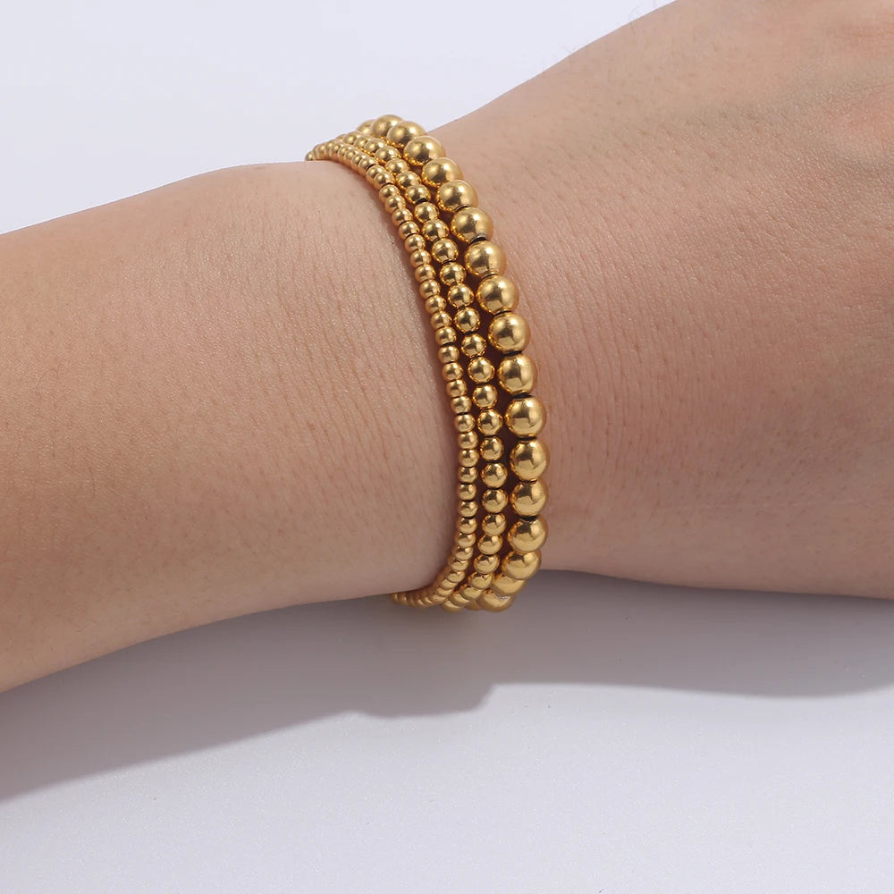 Set aus goldfarbenen Kugelarmbändern