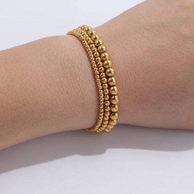 Set aus goldfarbenen Kugelarmbändern