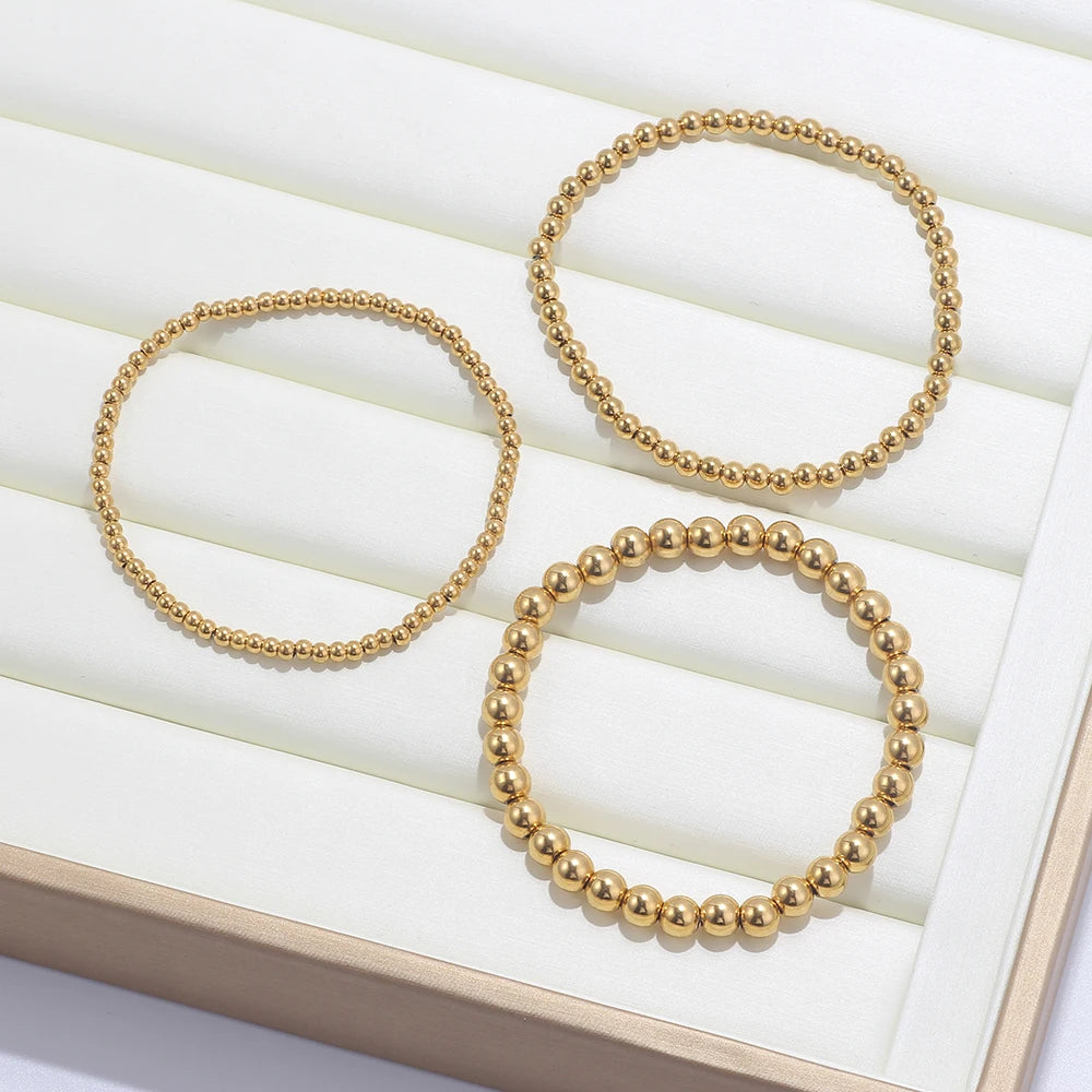 Set aus goldfarbenen Kugelarmbändern