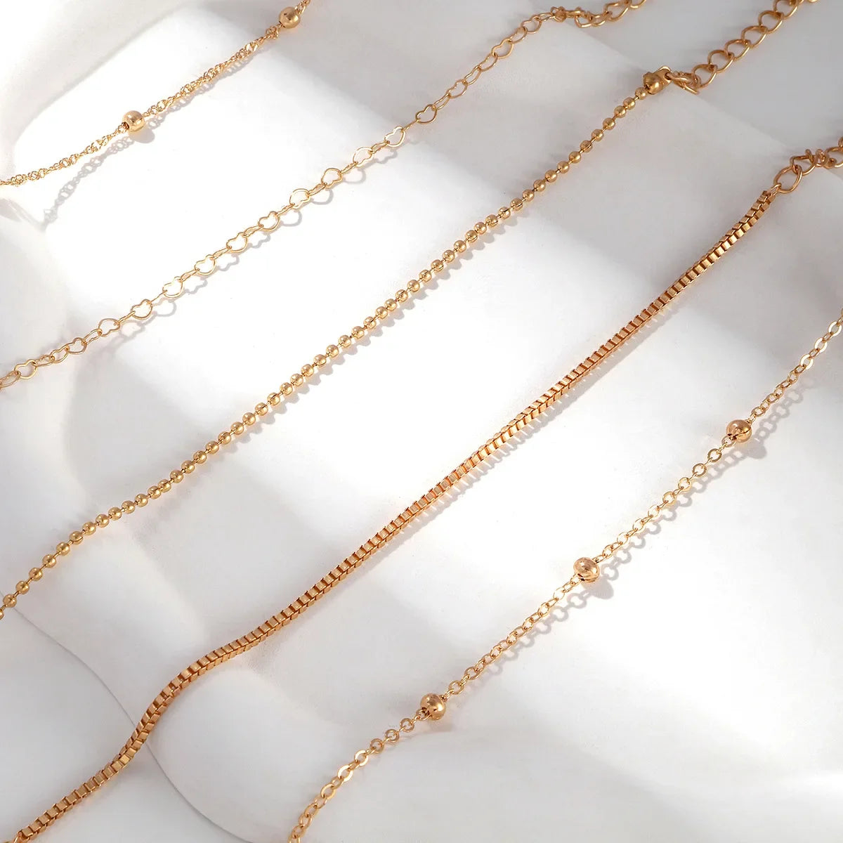 Set aus goldenen Armbändern im Ketten-Design